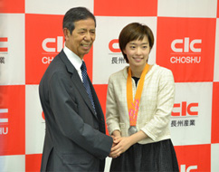 握手する石川佳純選手と岡本要社長