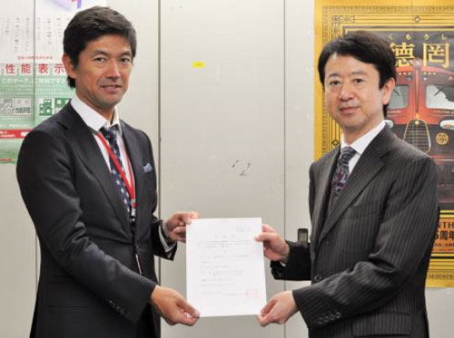 登録証の受け渡しをする国交省の林田康孝住宅生産課長(右)とリノベーション住宅推進協議会の内山博文会長(左)