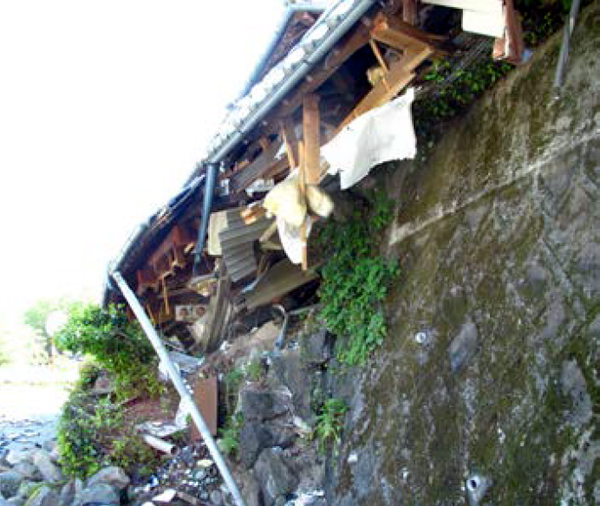 擁壁が崩れて倒壊した住宅