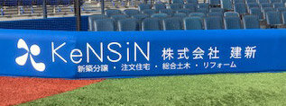 建新　「KeNSiN」のロゴと社名がエキサイティングシート三塁側に掲出されている