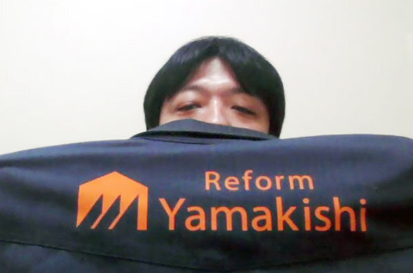 山岸　背中には「リフォームヤマキシ」の英字ロゴが入っている