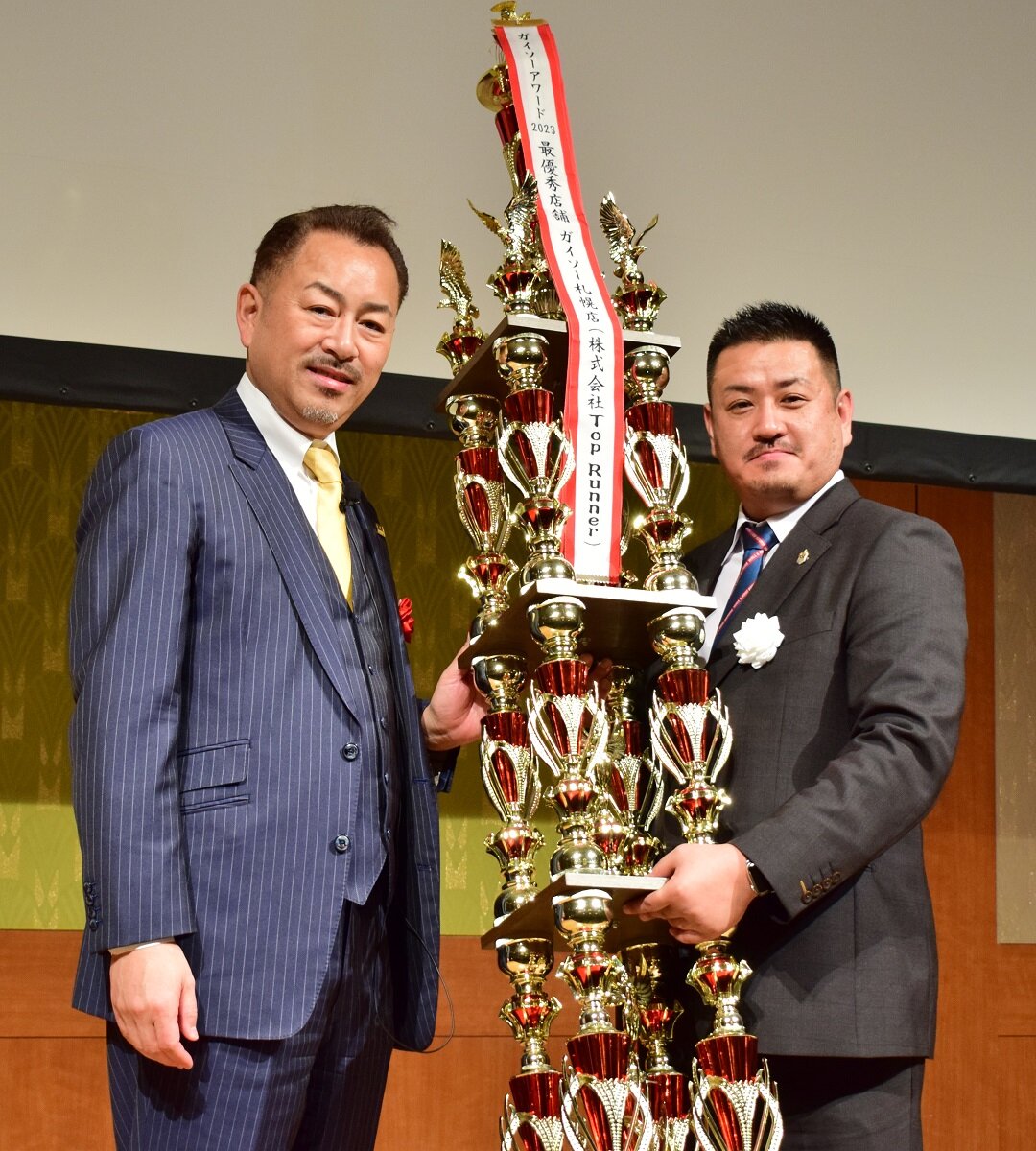 ガイソーグループ　建材販売店舗部門1位のガイソー札幌店のTop Runner 齊藤太基社長がトロフィーを受け取った。「去年4位で、今年いきなり1位になれると思っていなかったです。大変うれしく思います」と語った